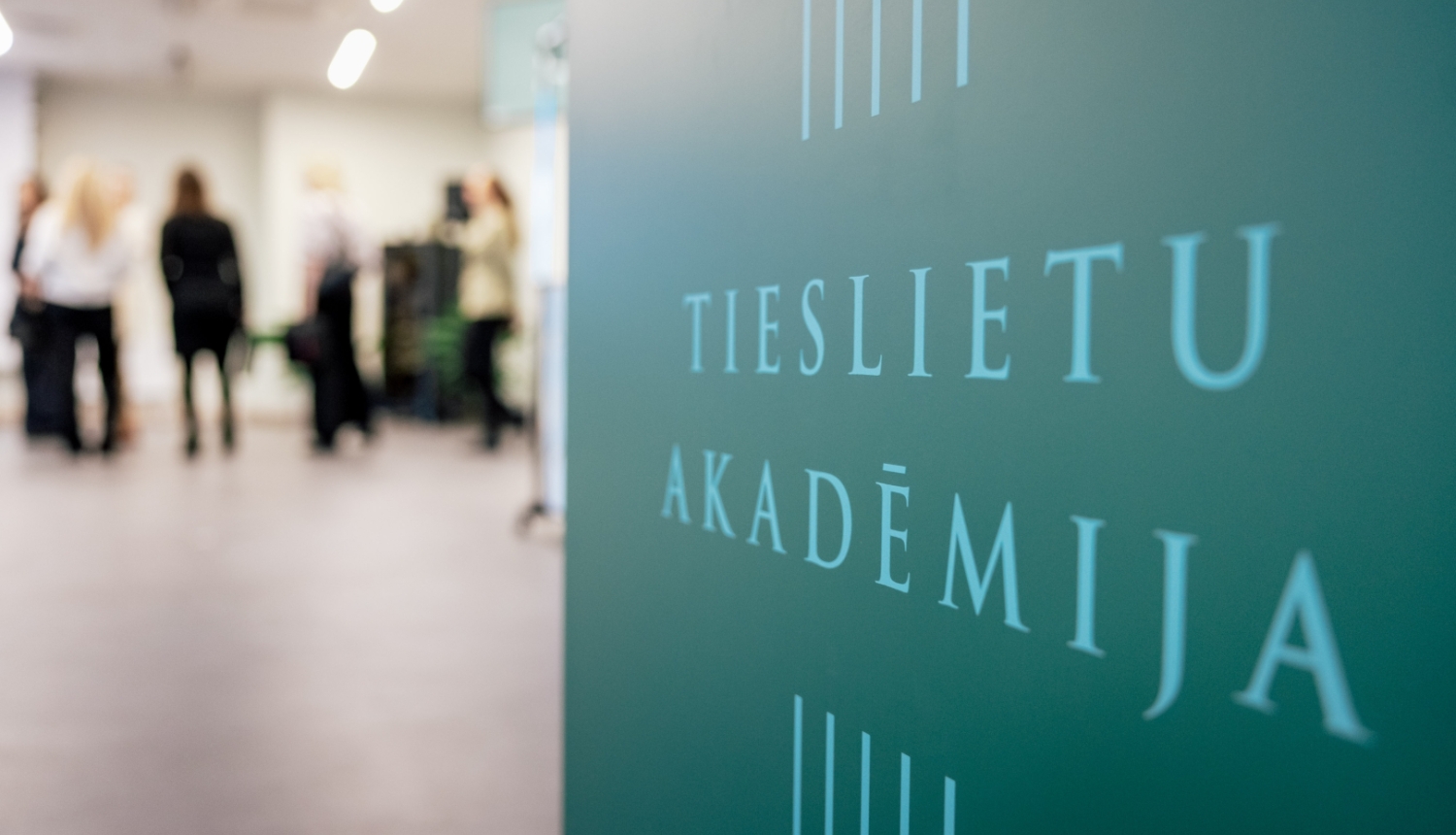 Tieslietu akadēmijas uzraksts uz zaļa fona
